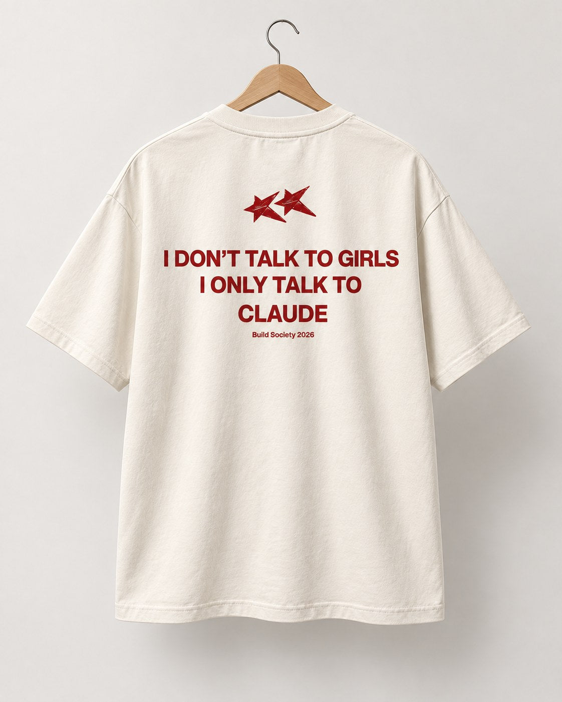 Dos du t-shirt crème Build Society sur cintre, deux étoiles rouges et la phrase imprimée en rouge