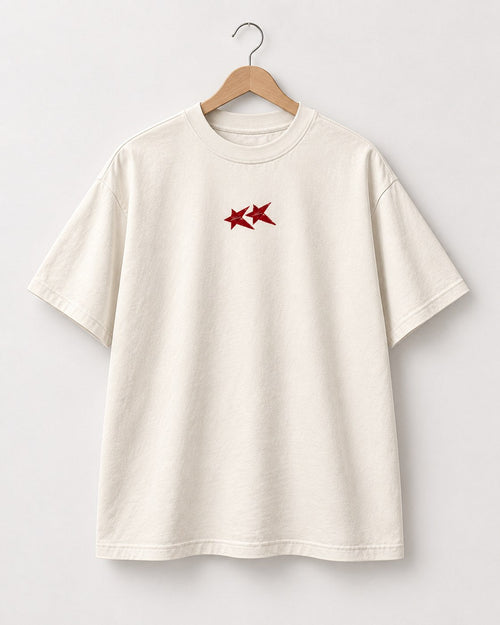 Face du t-shirt crème Build Society sur cintre, deux étoiles rouges sur la poitrine